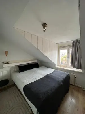 a bedroom with a large bed with a staircase at ZilverMoon in Egmond aan Zee