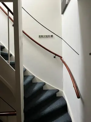 a stairwell with a white wall with a spiral staircase at ZilverMoon in Egmond aan Zee