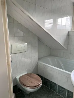 a bathroom with a toilet and a bath tub at ZilverMoon in Egmond aan Zee