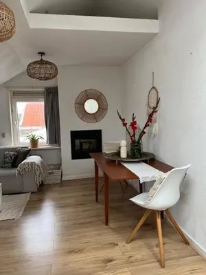 a living room with a table and a chair at ZilverMoon in Egmond aan Zee