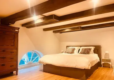 a bedroom with a bed and a dresser and a window at Historisch grachtenpand in centrum Gouda in Gouda