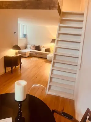 a white staircase in a living room with a table at Historisch grachtenpand in centrum Gouda in Gouda