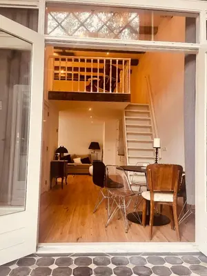 a living room with a dining table and a loft at Historisch grachtenpand in centrum Gouda in Gouda