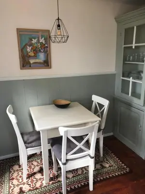 a white table and chairs in a kitchen with a painting at Appartement in schuur in Twisk