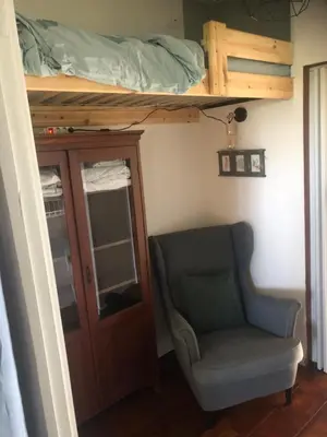 a bedroom with a bunk bed and a chair at Appartement in schuur in Twisk