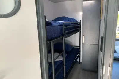 a room with three bunk beds in a room at Heerlijke Houseboat 