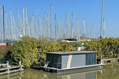 a small house on a boat in a marina at Heerlijke Houseboat 