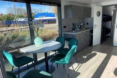 a kitchen with a table and chairs and a vase at Heerlijke Houseboat 