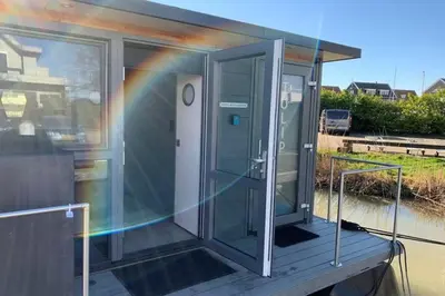 a house with a rainbow on the side of it at Heerlijke Houseboat 