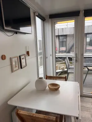 a white table with a vase on top of it at Houseboat Oslo perfect voor bezoek Amsterdam in Monnickendam