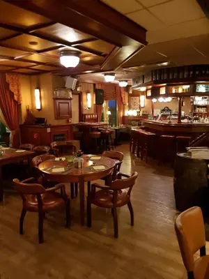 a restaurant with wooden tables and chairs and a bar at Hotel Zee en Duin in Katwijk
