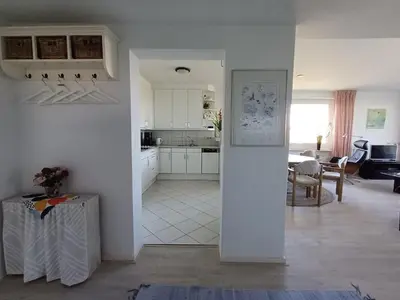a kitchen and living room with white cabinets and a table at JulianaDuin in Bergen aan Zee
