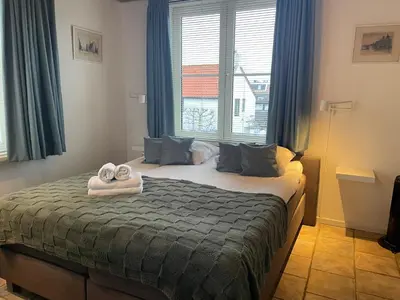 a bedroom with a bed with towels on it at Rozenobel apartment in Zandvoort