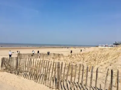 a group of people walking on the beach at Rozenobel apartment in Zandvoort