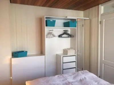 a bedroom with a bed and a closet at Rozenobel apartment in Zandvoort