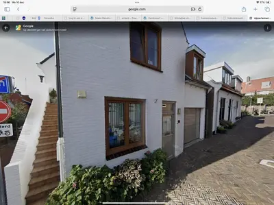 a white house with a window on a street at Rozenobel apartment in Zandvoort