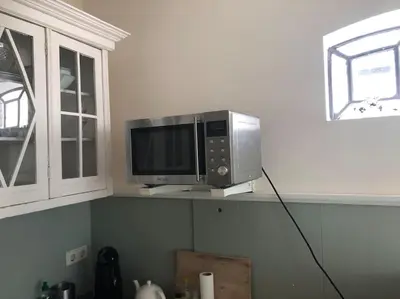 a microwave sitting on a shelf in a kitchen at Appartement voor twee personen in Twisk