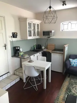 a kitchen with a white table and chairs in a room at Appartement voor twee personen in Twisk
