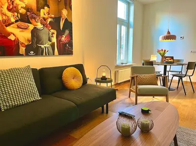 a living room with a green couch and a table at Stadscentrum, rustige toplocatie! in Amersfoort