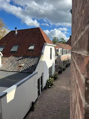 an alley in a town with white buildings at Stadscentrum, rustige toplocatie! in Amersfoort