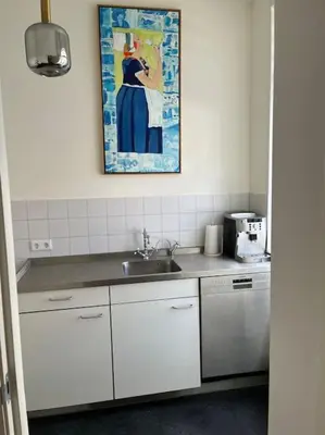 a kitchen with a sink and a painting on the wall at Stadscentrum, rustige toplocatie! in Amersfoort