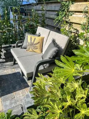 a bench with pillows on a patio with plants at Amsterdam Beach House in Zandvoort