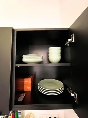 a cabinet with plates and bowls in it at Amsterdam Beach House in Zandvoort