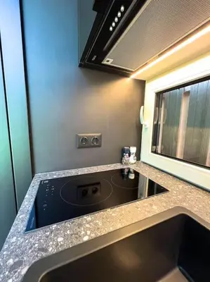 a kitchen counter with a stove and a microwave at Amsterdam Beach House in Zandvoort