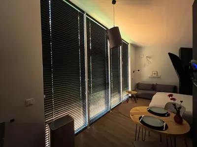 a living room with a table and a large window at Amsterdam Beach House in Zandvoort