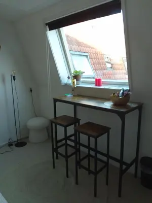 a bathroom with a table and stools in front of a window at Kraaipan B&B in Amsterdam