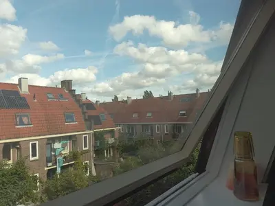 a window with a view of a city with buildings at Kraaipan B&B in Amsterdam