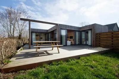 a modern house with a picnic table on a deck at Dunes of Egmond in Egmond-Binnen