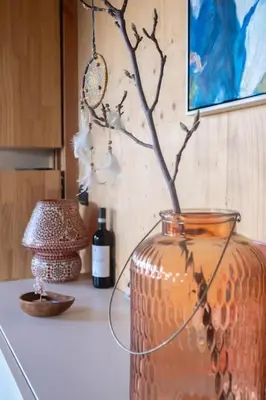 a vase sitting on a counter with a lamp and a bottle of wine at Dunes of Egmond in Egmond-Binnen