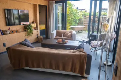 a living room with a bed and a couch at Dunes of Egmond in Egmond-Binnen