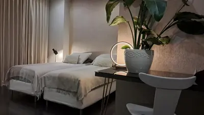 a bedroom with a bed and a potted plant on a table at The Fabulous Suite in Amsterdam