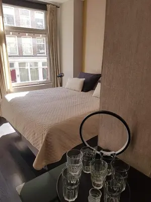 a bedroom with a bed with glasses on a table at The Fabulous Suite in Amsterdam