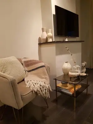 a living room with a chair and a table with a tv at The Fabulous Suite in Amsterdam