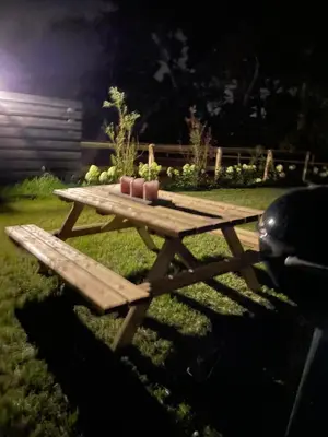 a wooden picnic table with three pink candles on it at Guesthouse ML in Hillegom