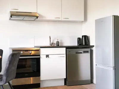 a kitchen with white cabinets and a refrigerator at Guesthouse ML in Hillegom