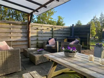 a patio with a wooden table and chairs at Guesthouse ML in Hillegom