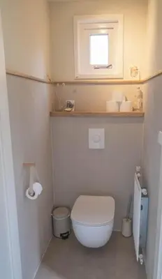 a small bathroom with a toilet and a window at Duinhuis Zout Hout in Egmond-Binnen