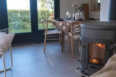 a stove in a room with a table and a dining room at Duinhuis Zout Hout in Egmond-Binnen
