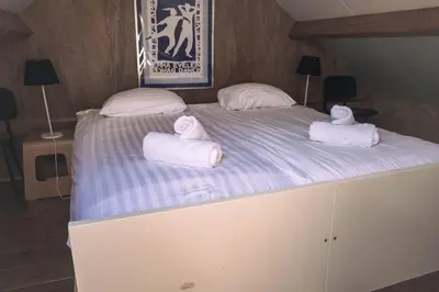 a large bed with two towels on top of it at Vakantiewoning MV8 in Egmond-Binnen