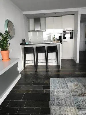 a kitchen with a counter and some bar stools at Berrie's Sea View in Zandvoort