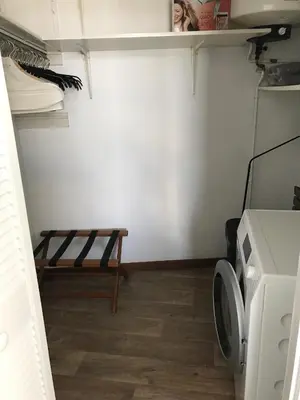 a laundry room with a bench and a washing machine at Berrie's Sea View in Zandvoort