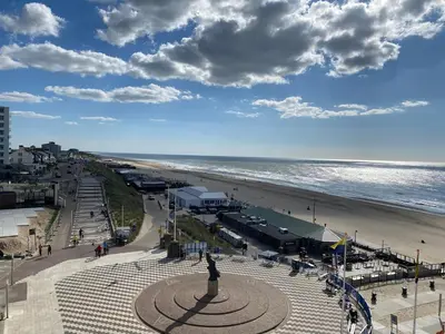 a view of a beach with a statue and the ocean at Berrie's Sea View in Zandvoort