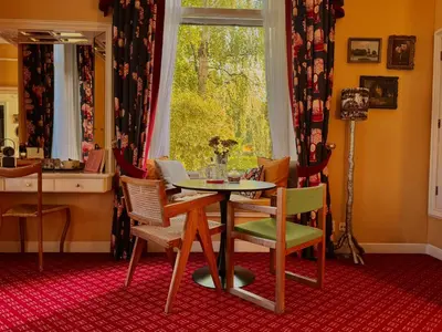 a dining room with a table and chairs and a window at Villa Abbekerk - Bed & Breakfast in Abbekerk