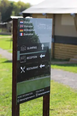 a sign in the grass with arrows on it at Safari Lodges in Nieuwe Wetering