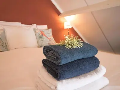 a pile of towels sitting on top of a bed at Hosted by wendy Old city charming accommodation in Wassenaar