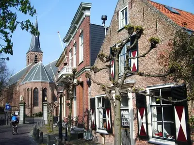 a man riding a bike in front of a brick building at Hosted by wendy Old city charming accommodation in Wassenaar